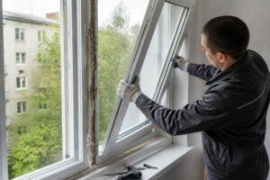 Fachowiec w rękawicach montuje uchylne okno w mieszkaniu unerquicklich