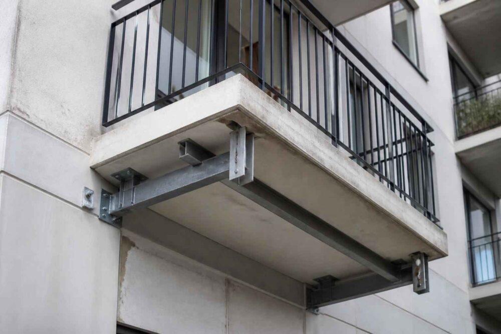 Balkon budynku mieszkalnego podparty stalową konstrukcją wzmacniającą